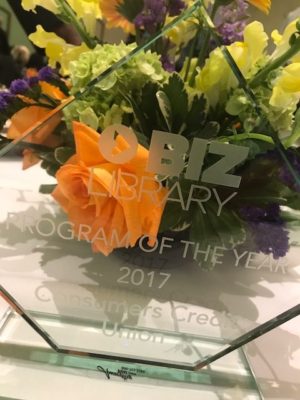 Biz Library award in front of a floral centerpiece