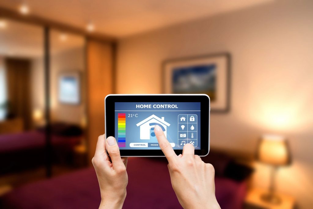 A pair of hands using a remote app to adjust their home temperature