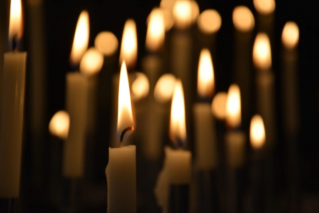 A group of candles burning in a dark room