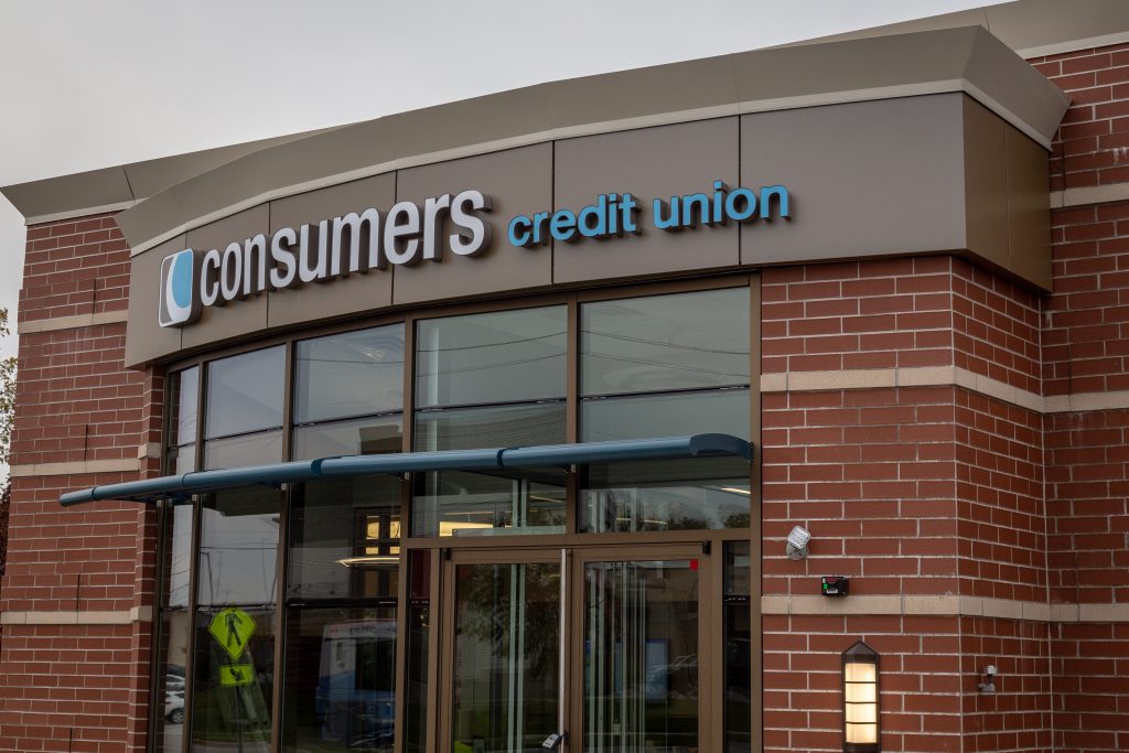 The front of a Consumers Credit Union location on an overcast sky
