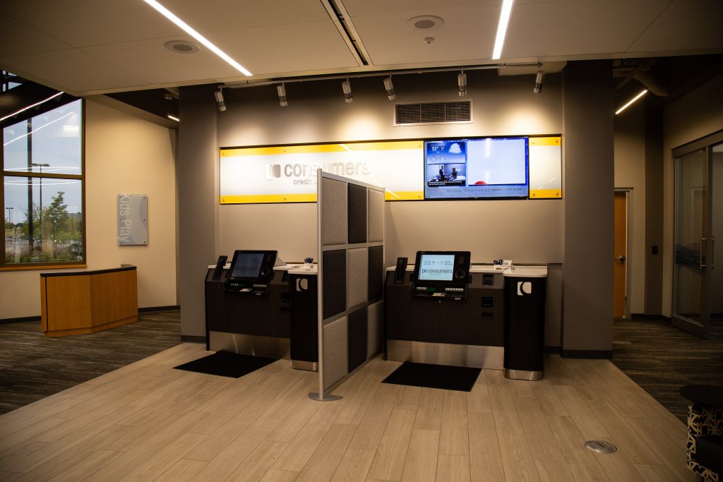 Two banking kiosk separated by a grey and black checkerboard partition