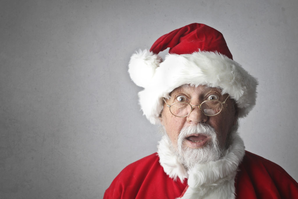 A man dressed like Santa Claus with a surprised look on his face.