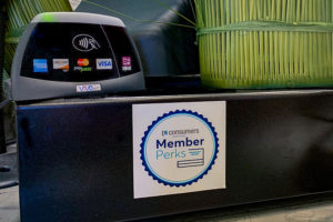 A Consumers Credit Union Member Perks on a cash register in a retail setting.
