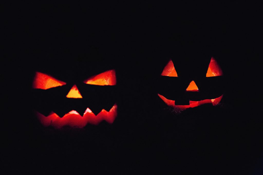 Jack-o'-Lantern faces glowing in the dark.