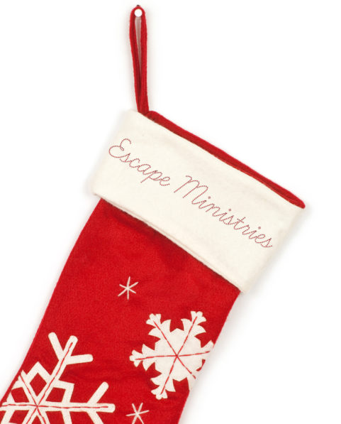 Escape Ministries red Christmas Stocking with snowflake designs.