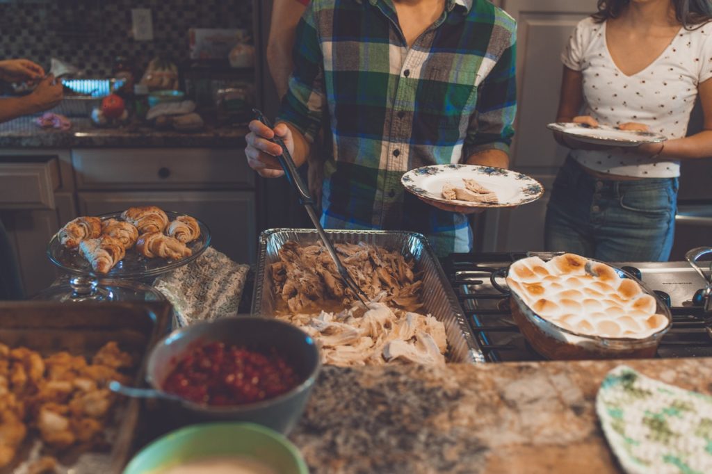 Family members in a buffet line for a Thanksgiving Day meal.