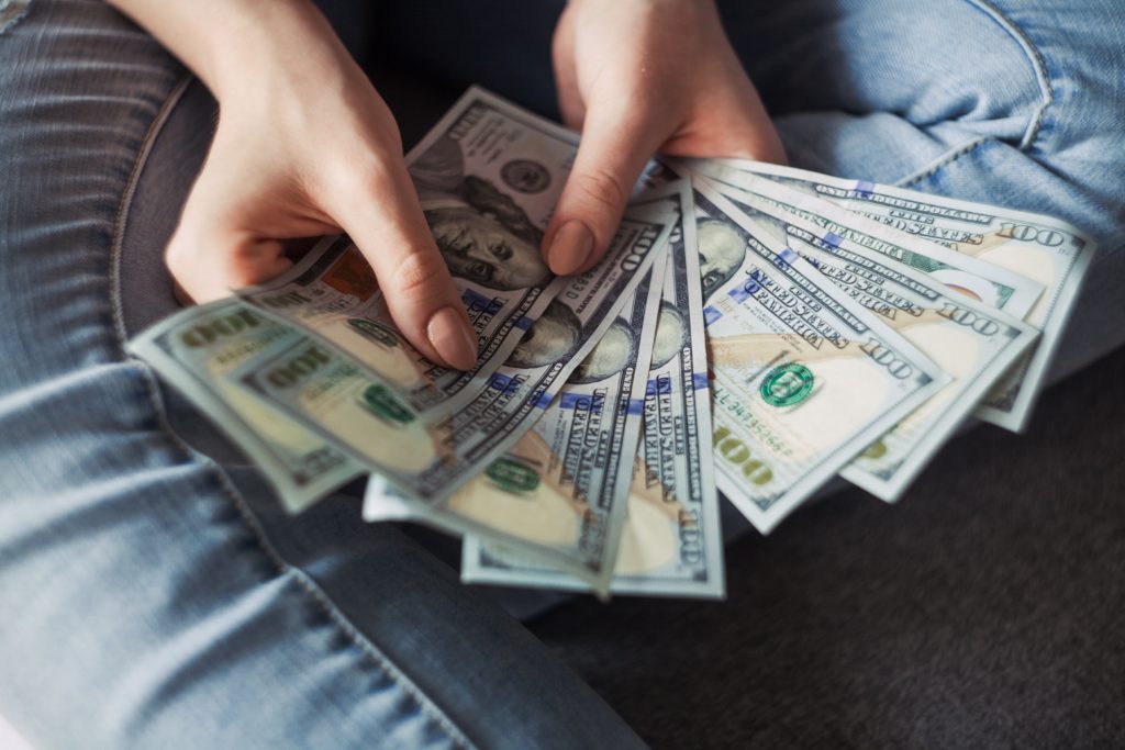 A woman fanning out $100 bills.