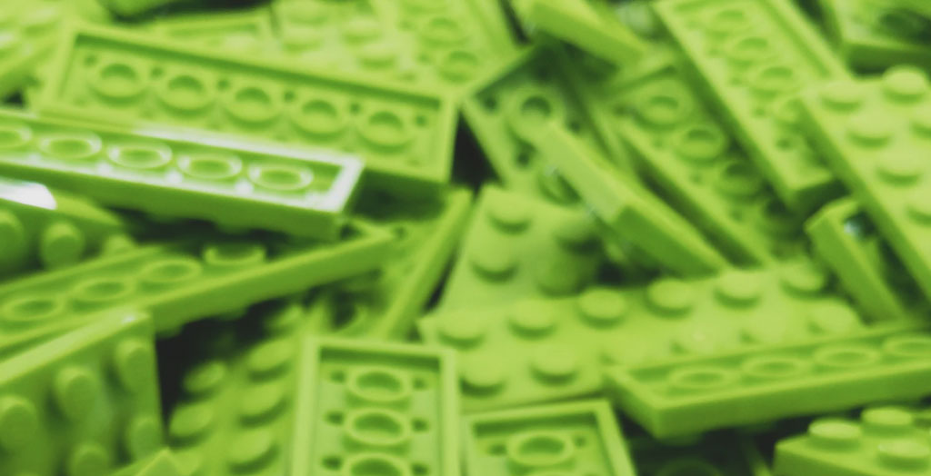 A pile of lime green flat rectangular LEGO pieces.
