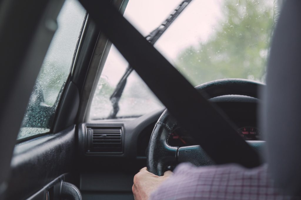 Interior of blue car driving through rain.