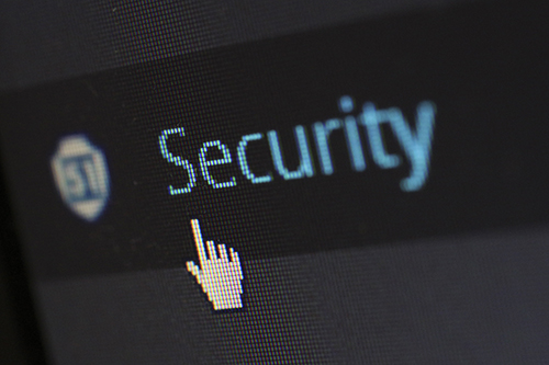 A mouse hand pointer pointing on a computer screen pointing at the word "security".