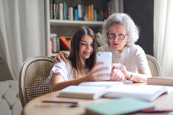 Woman showing her cellphone to her grandmother.