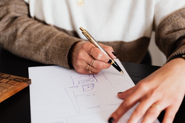 Woman scribbling house plans on a piece of white paper