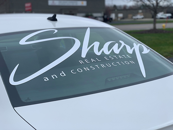 Back windshield of Sharp Real Estate and Construction car