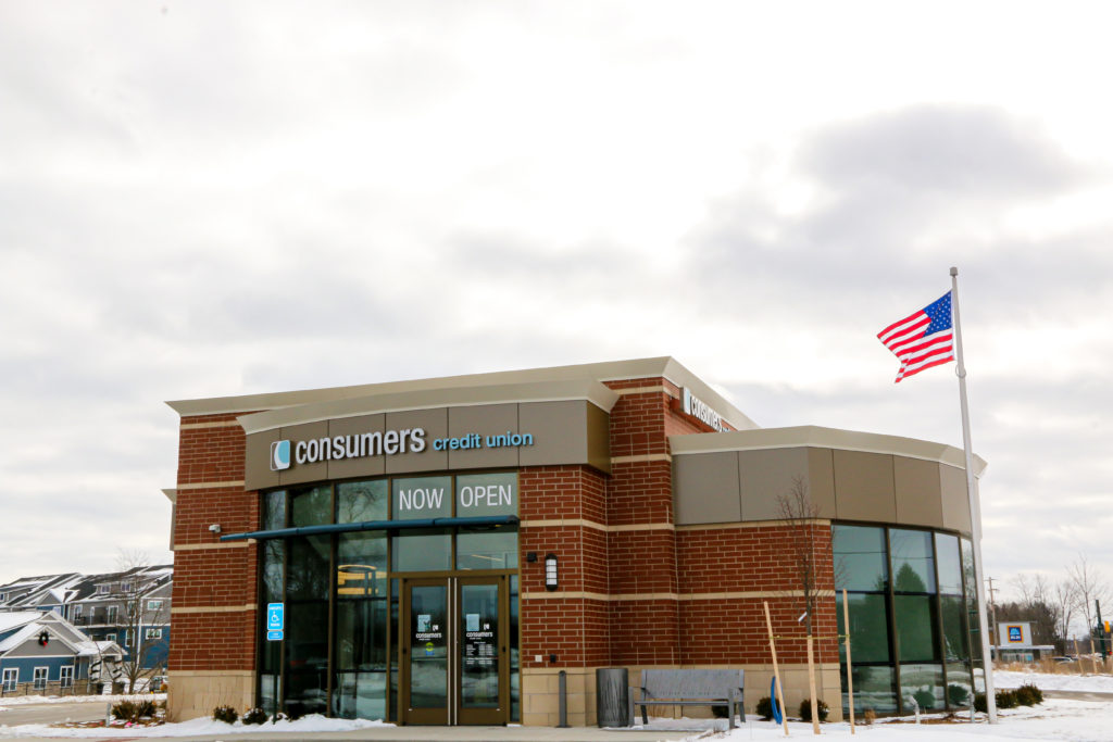 The exterior of the Consumers Credit Union Walker location on a snowy day with an overcast sky.