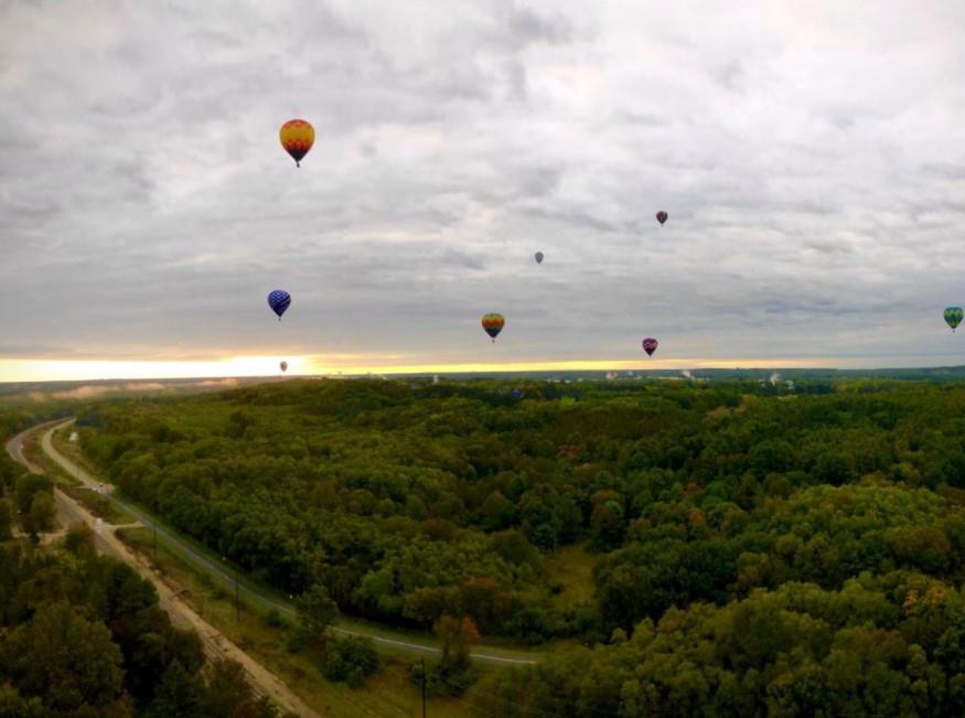 Eight colorful hot air balloons flying at sunrise in Battle Creek, Michigan.