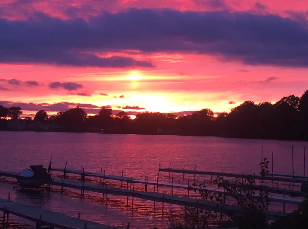 Colorful sunset shining on docks in the foreground on Green Lake near Traverse City, Michigan.