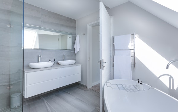 A white and grey bathroom with a clawfoot tub and a shower.