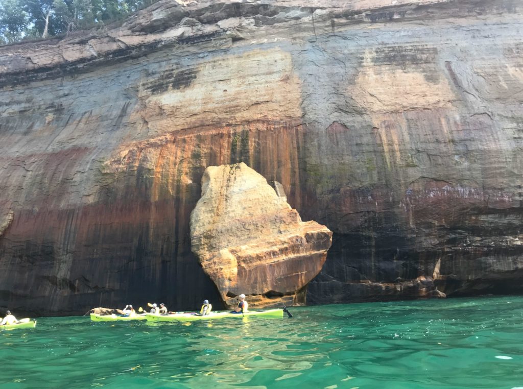 Kayakers enjoying the majestic beauty of the Pictured Rocks in Lake Superior.