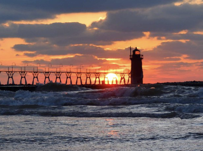 The pier and Lighthouse in South Haven, Michigan overlooking Lake Michigan at sunset.