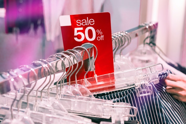 50% off sale tag on clothing store rack