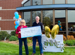 Wanda Allred and husband accept $10,000 outside of Consumers Credit Union Milwood Office.