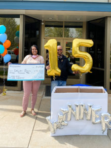 DeLight Brown and husband accept $15,000 check in front of Consumers Credit Union Milham Office.
