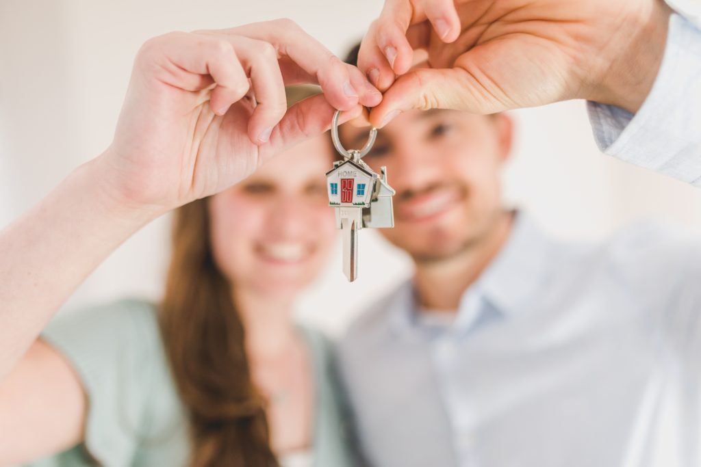 Male and female couple holding a new set of house keys.