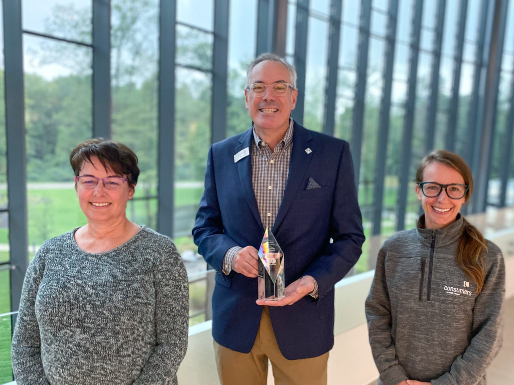Jorgene Hallet, Steve Owens and Jennifer Smith pose for a photo with the crystal Mastercard Community Institution Award.