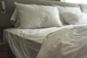 A bed with white, rumpled sheets.