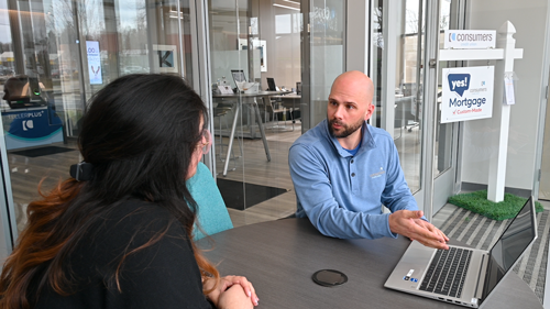 Female member learns about mortgage rates from worker in office.