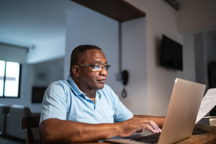 Senior man working from home using laptop