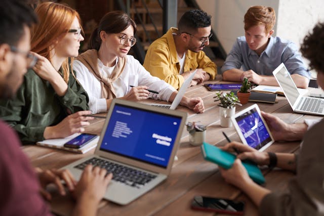 A group of coworkers sitting around a table having a meeting.