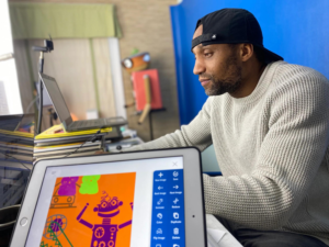 Michael Hyacinthe, creator of Wimee, sitting at a desk working.