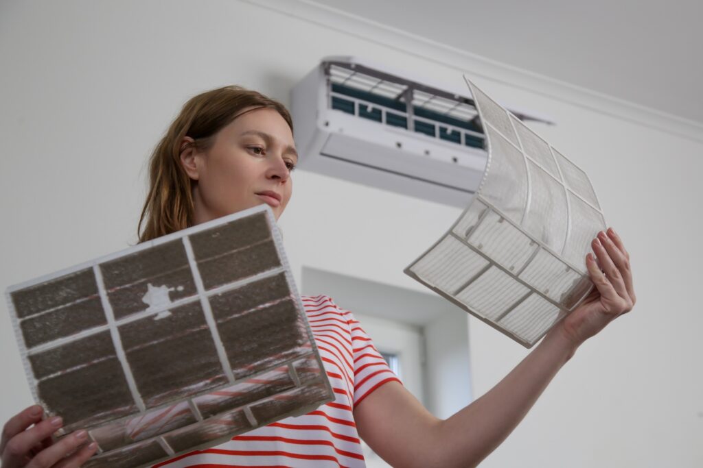 Woman replacing an old dusty air filter with a new one.