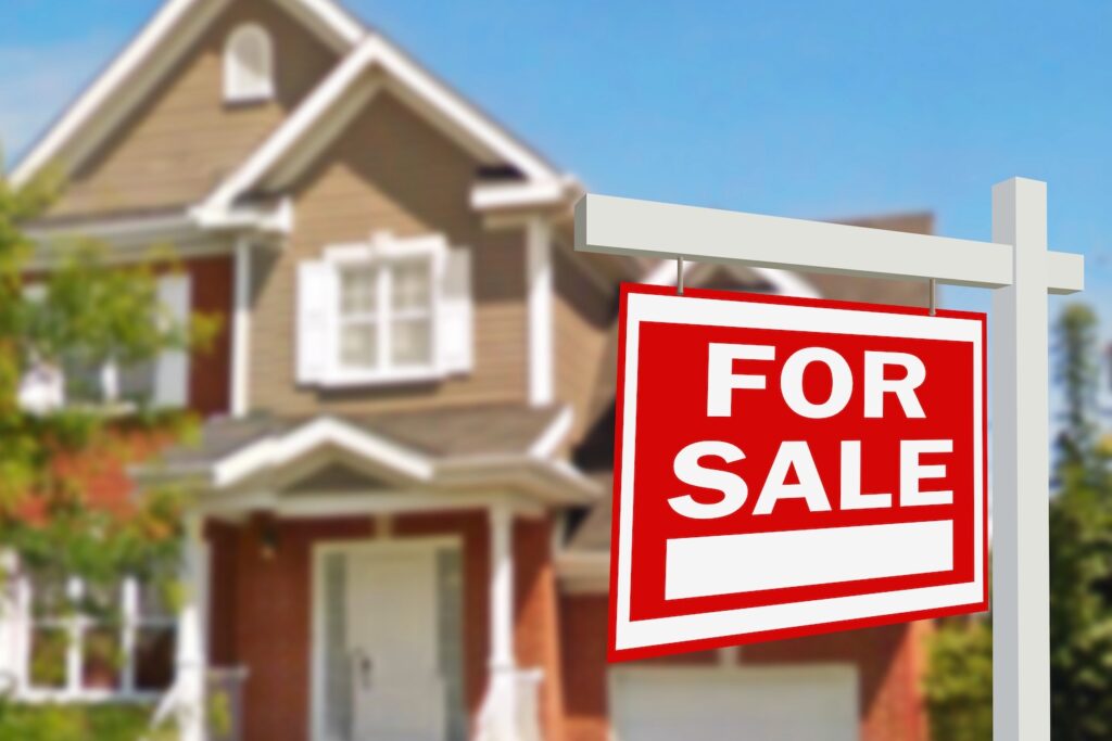 House with a for sale sign in front of it.