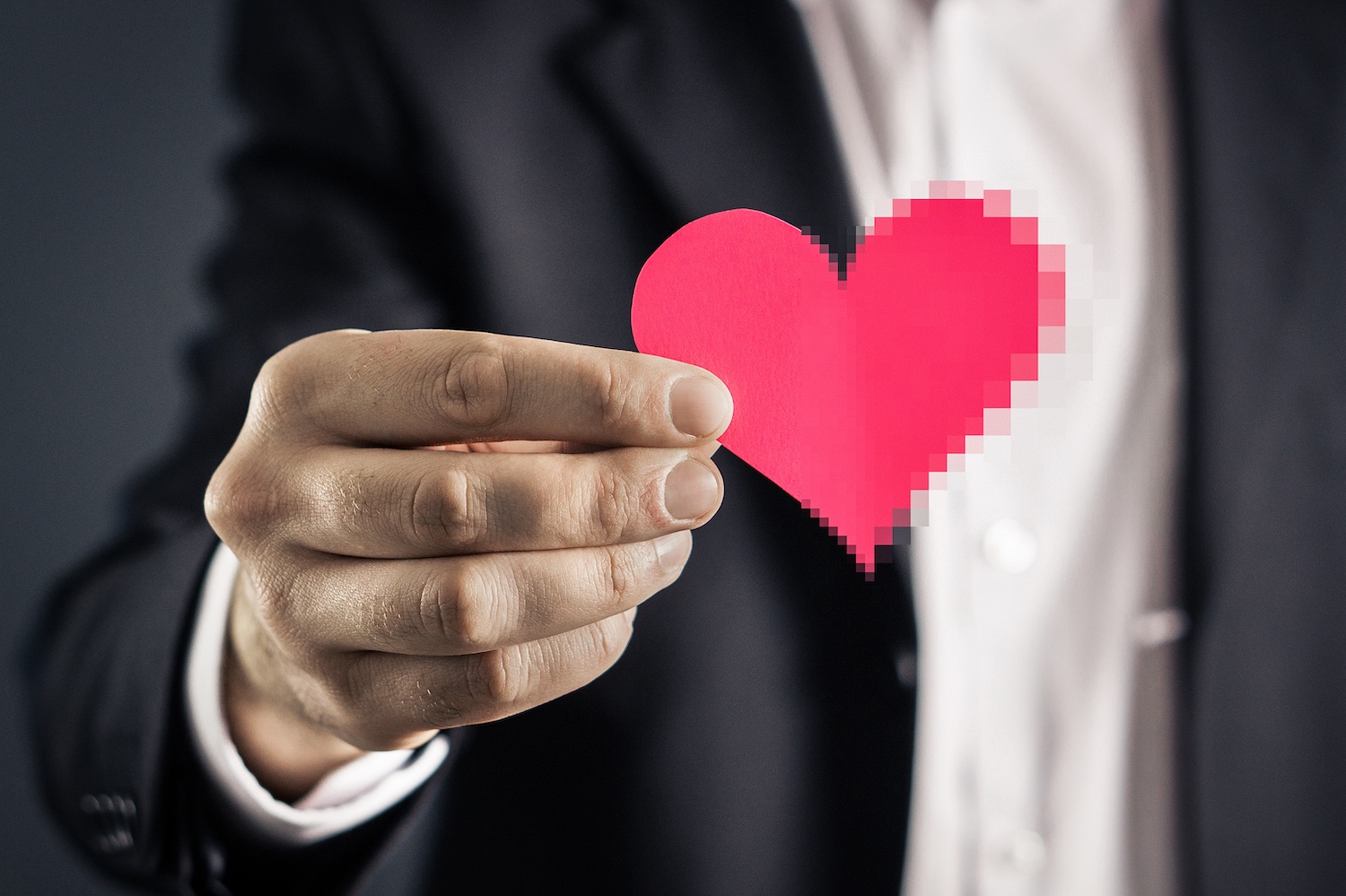 Person holding a heart that is turning pixelated.