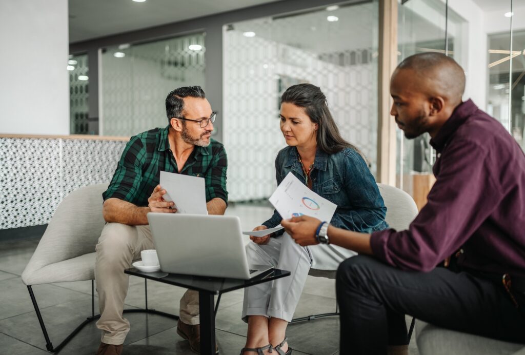 Couple sitting with a financial advisor looking over paperwork.