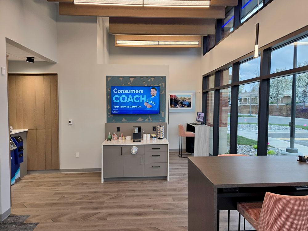 Inside photo of Rockford Office showing coffee station and lobby screen