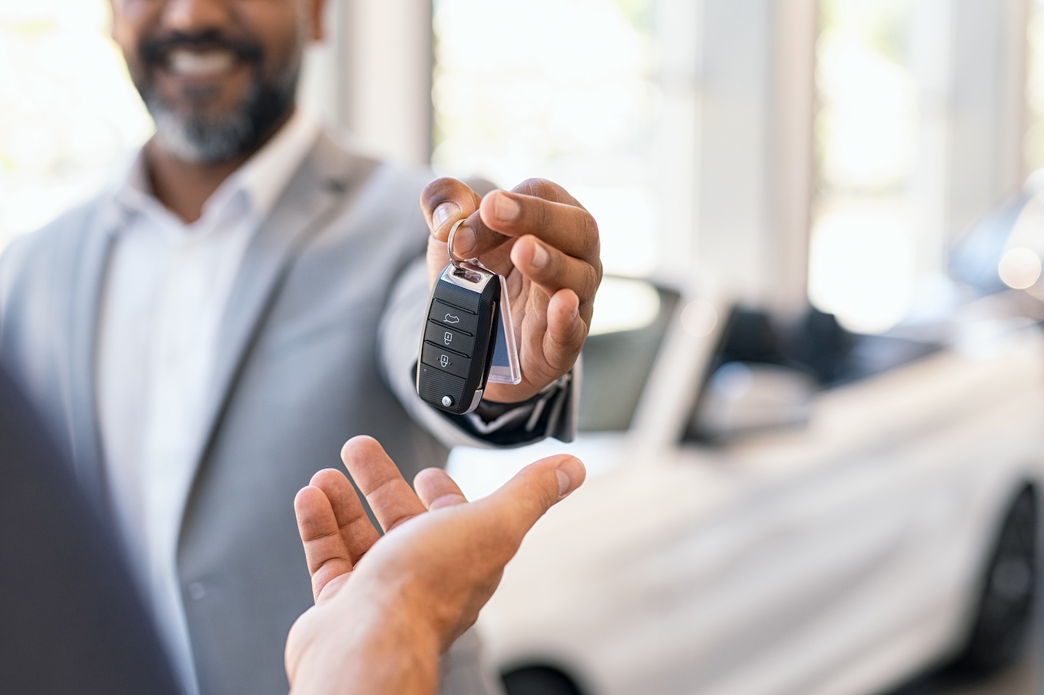 Car salesman handing over keys to a car.