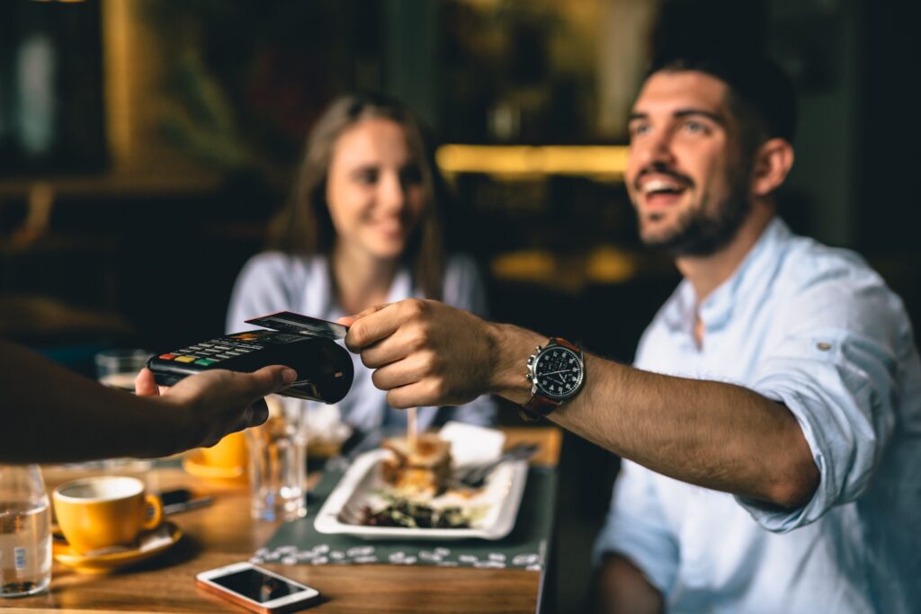 Man paying the bill at a fancy restaurant.