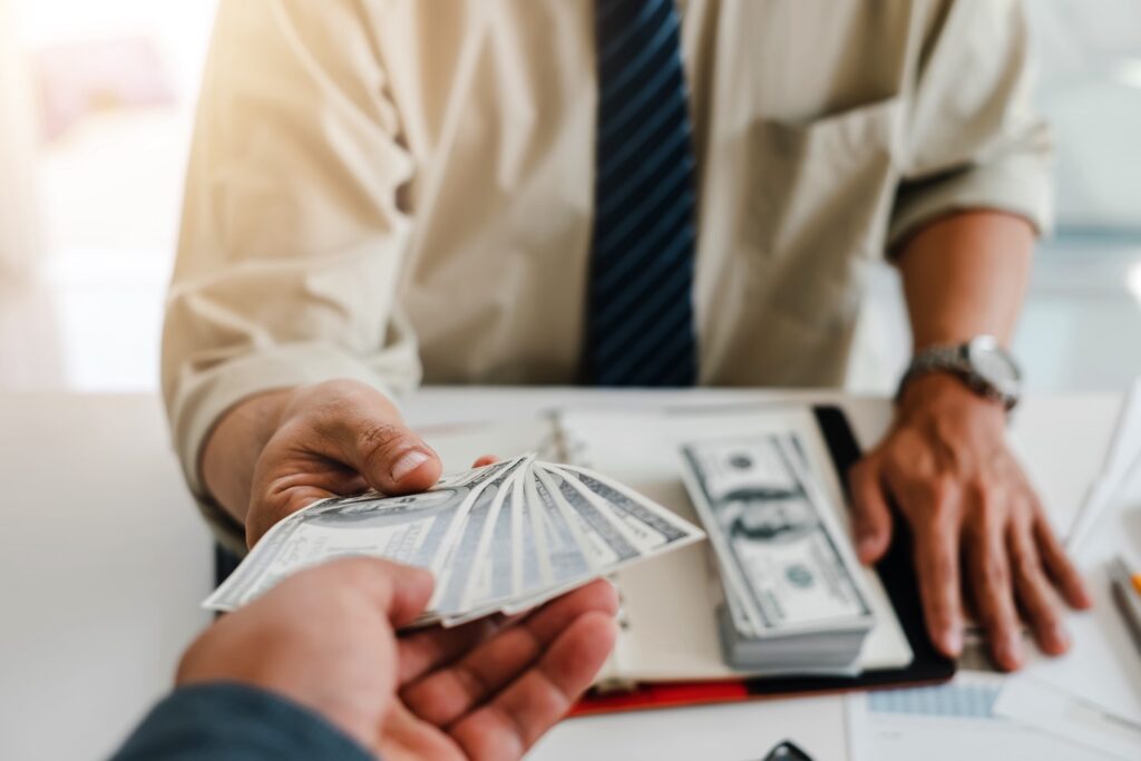 Person handing money to another person.