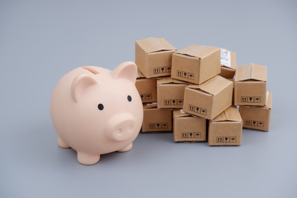 Piggy bank sitting next to boxes.