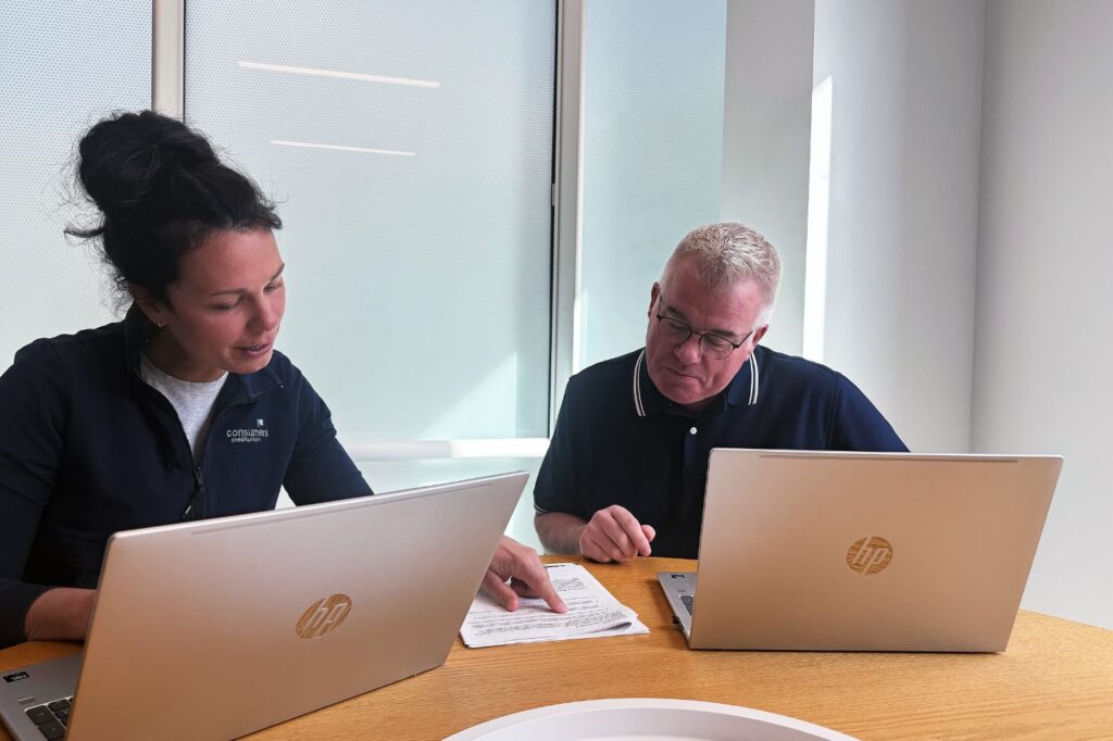 Two members of the Consumers HELOC team looking over paperwork.