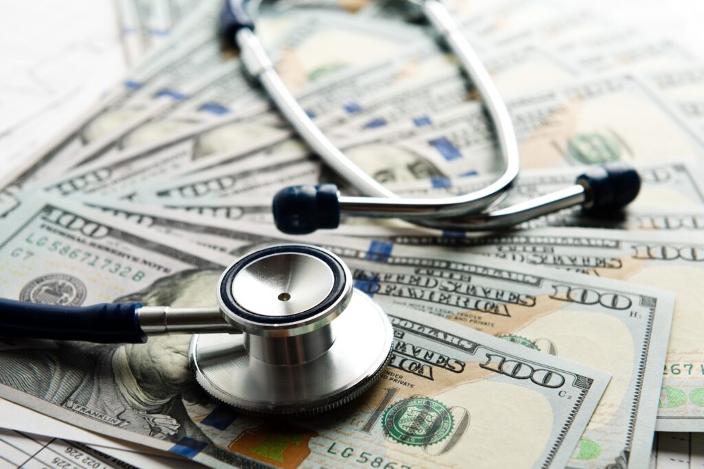 Stethoscope laying on top of money.