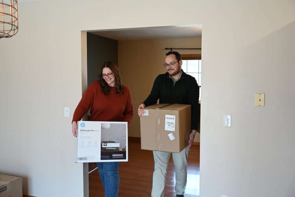 Happy young couple moving boxes into their new home.