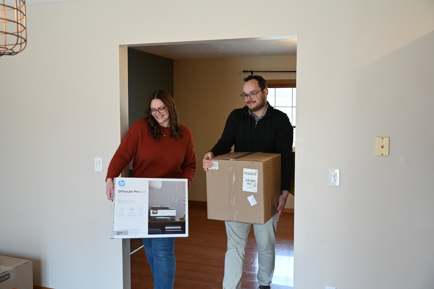 Happy young couple moving boxes into their new home.