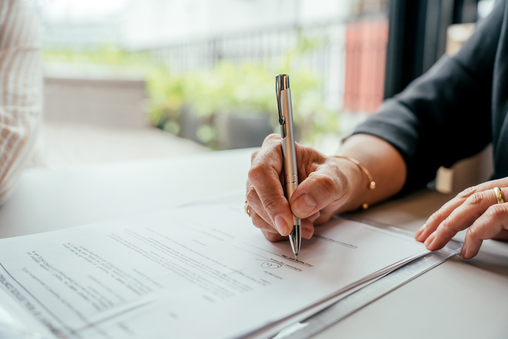 Couple closing real estate contract with real estate agent
