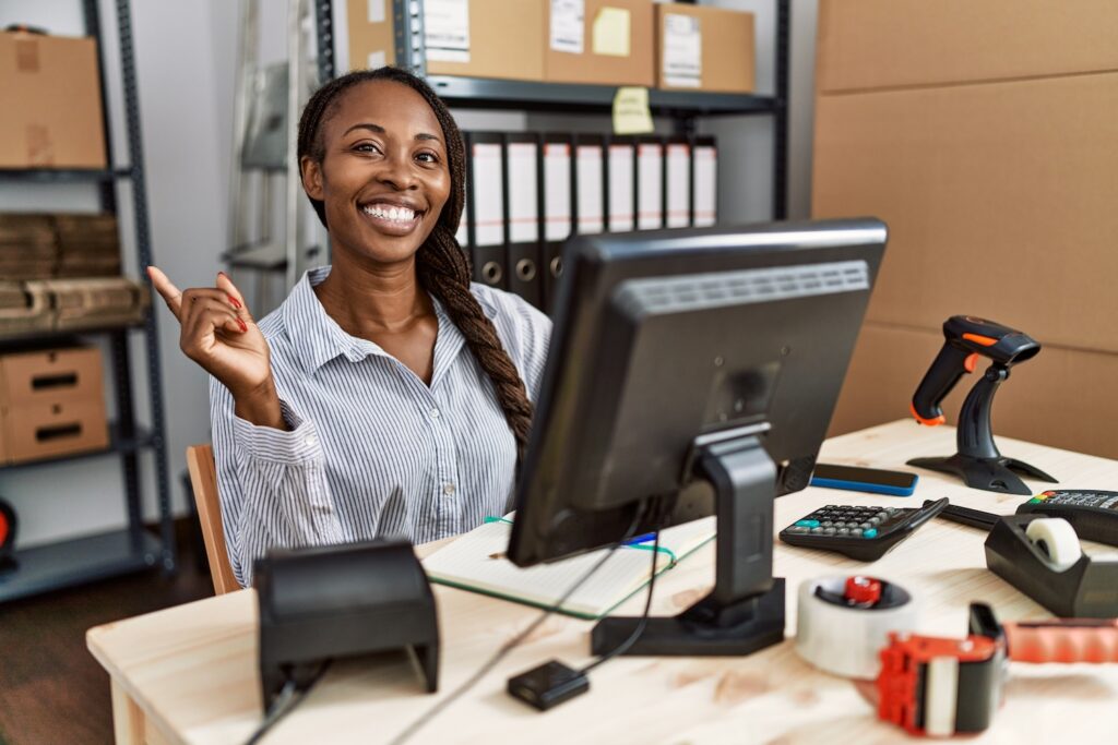 Female business owner smiling while sitting at her desk.