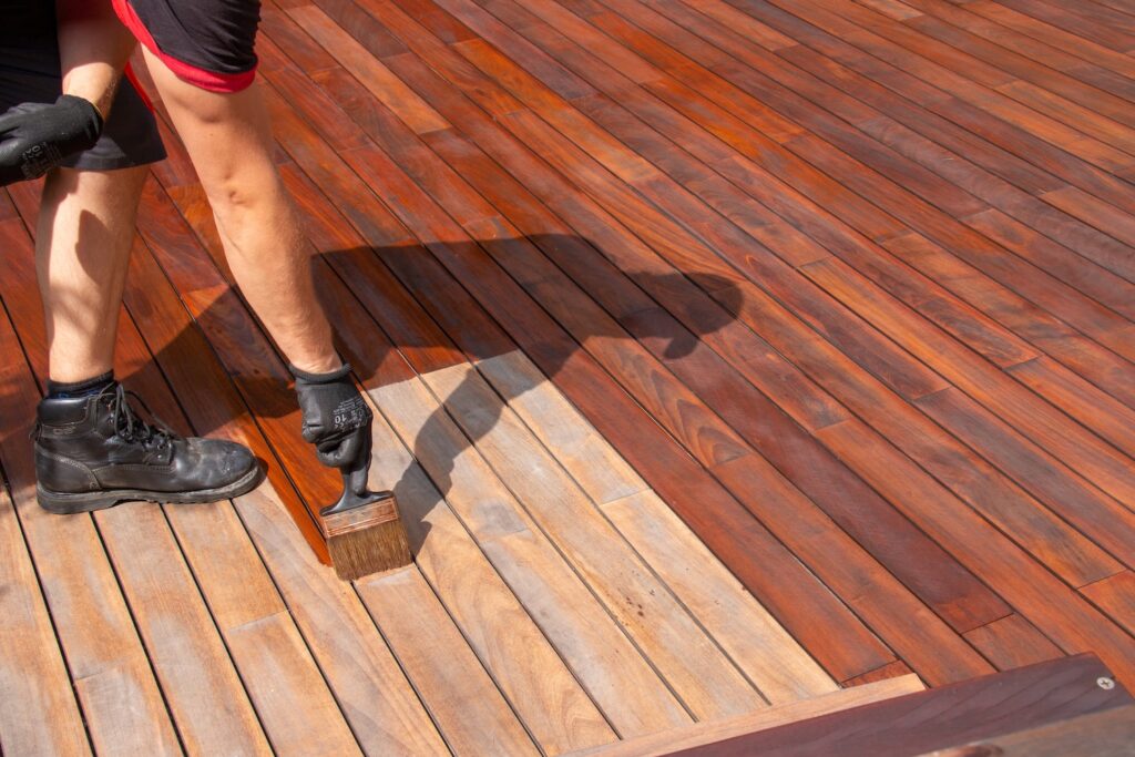 Person staining a deck.