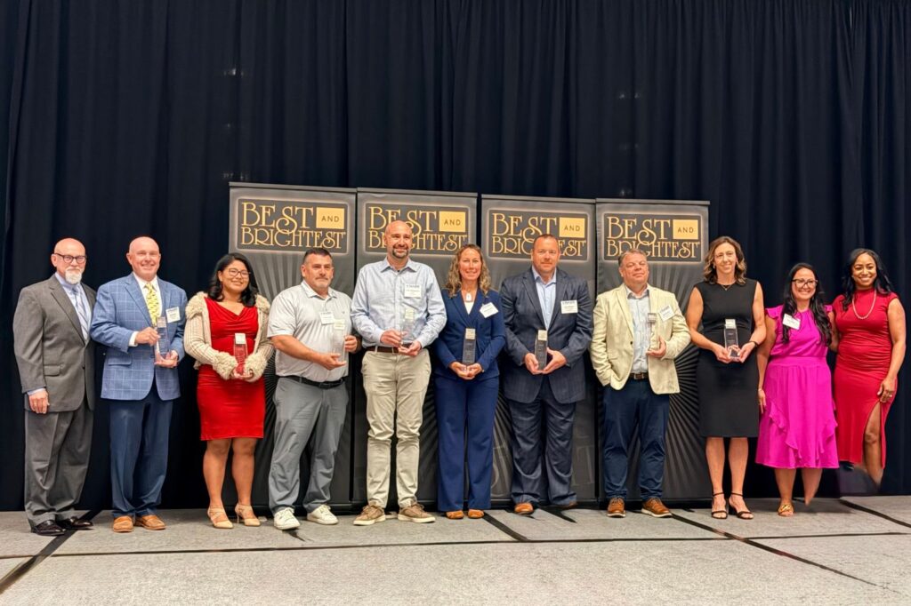 Group of Best and Brightest award winners standing together with their awards.